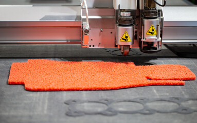 CNC laser cutting machine cutting car carpet mat and engine gasket. Industrial manufacturing