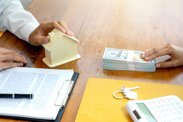 The businessman is handing the house keys  to the contracted