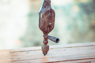 Old manual mechanical vintage retro drill on the workbench