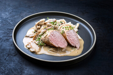 Modern style traditional barbecue Iberian pork filet medaillons in cream sauce with mushrooms and...
