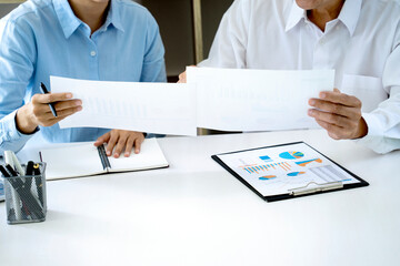A businessman mentor and intern  woman staff consultant holding graph paper