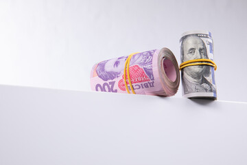 rolls of dollars and hryvnias isolated on white background, close view