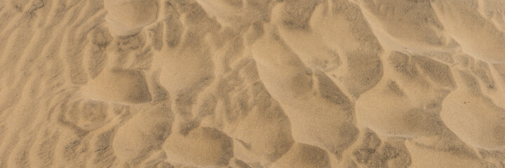 Panoramic sandy background. Sand on the beach formed by wind
