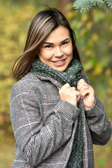 Portrait of a young woman in casual plus-size clothing on the background of autumn foliage in the Park