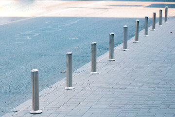 Stainless parking poles separating the sidewalk from the road. Prevention. Illegal. Control. Urban....