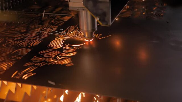 Laser cutting machine working with sheet metal with sparks at factory, plant - slow motion. Metalworking, industrial, equipment, technology, machining, manufacturing concept
