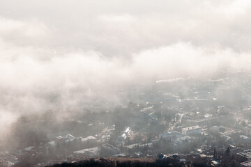Aerial view of the city through the clouds from the top of the mountain.