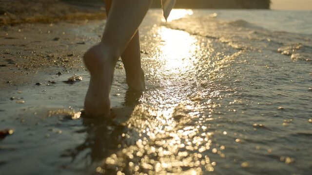 Walking feet on the coast with a beautiful sunset