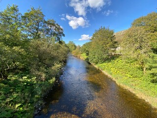 The river Skirfare, with tree lined banks, as it passes through the hamlet of Hawkswick, deep in the Yorkshire dales