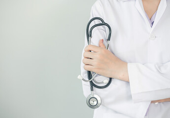 female doctor holding stethoscope in hand standing in white background copy-space. hospital and professional concept