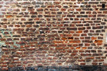 old wall made of rectangular red bricks sealed with cement