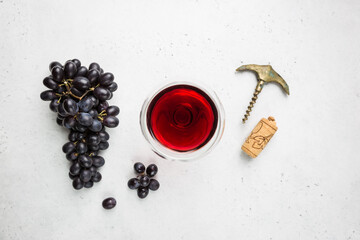 Red wine in a glass and ripe grapes on white background, top view