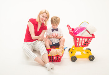 Shopping, discount, sale concept. Mother with son on shopping. Little boy with mother in shop. Kid plays in shop. Boy at shopping. Little kid with plastic shopping trolley.