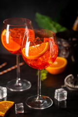 Aperol spritz cocktail in glass with fresh orange on dark background