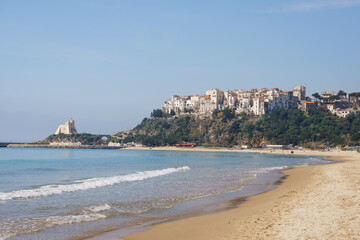 view of the beach. ancient castle on the seashore. coast of italy. yellow sand and blue sea. coastal town