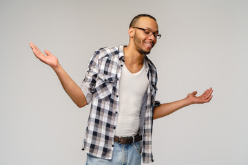 I don't know gesture - Young afrcian american man over grey background being at a loss, showing...