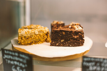Chocolate and caramel vegan desserts on display in  cafe. Pastry shop. 