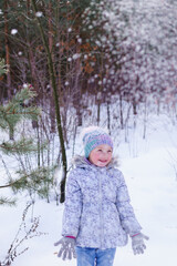 little child playing in snow. sincere joy of the child from playing in the fresh air. raising immunity in winter. playing snowballs in the winter forest