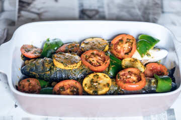 baked fish dish, Mediterranean food, baked sea bass with tomatoes and potatoes 
