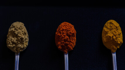 spoon of paprika on black background