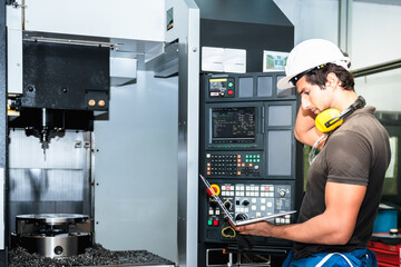 Engineers, Technicians caucasian man, Using a laptop computer To help set up the system of the machine, And machine operation which controlled by electric laser system