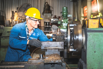 Engineers, technicians man are working by controlling steel lathes, in parts production line at workplace in the industrial factory, to worker concept.