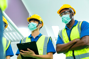 Professional engineering walking discuss inspecting with engineer team in clean room machinery factory area. Manager hand use tablet listenreport paper for internal audit. New normal factory concept