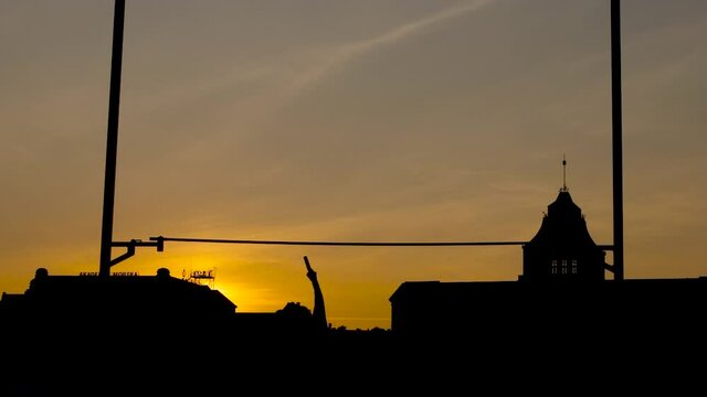 Evening silhouette of a Professional Olympic Pole Vault Athlete Training & Failing against Magnificent Sunset
