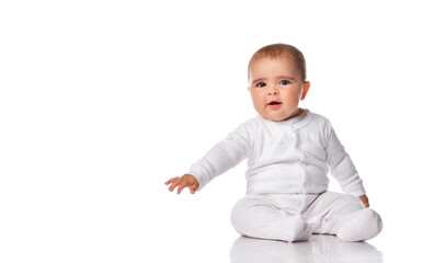 Intrigued baby in a white bodysuit looks to the side on a white background.