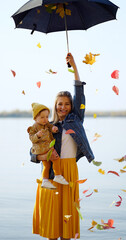 mom and daughter on the beach with umbrella with leaves. - 382879051