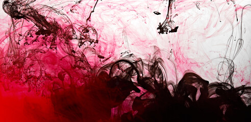 Closeup of a red and black ink in water in motion isolated on white. Ink swirling underwater....