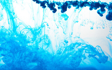 Obraz premium Closeup of a blue ink in water in motion isolated on white. Ink swirling underwater. Colored abstract smoke explosion effect. Abstract background with copy space..