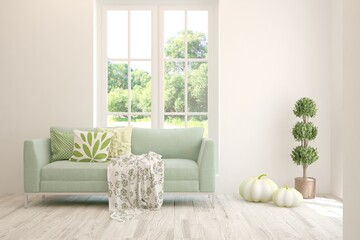 White living room with sofa and summer landscape in window. Scandinavian interior design. 3D illustration