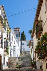 Fototapeta na wymiar Cuesta de Abarqueros, typical narrow pedestrian street with steps in the Albaicín neighborhood in Granada
