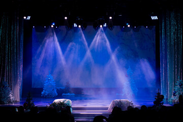 Theater before the performance of artists. Bright colored light and scene with Christmas trees.