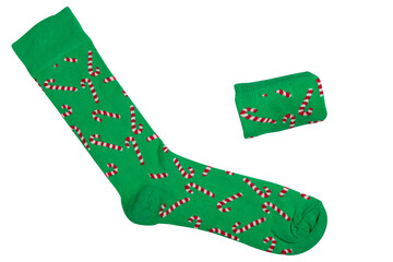 pair of green socks with Christmas pattern, one sock laid out and the other folded into a roll, on a white background