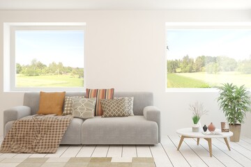 White living room with sofa and summer landscape in window. Scandinavian interior design. 3D illustration