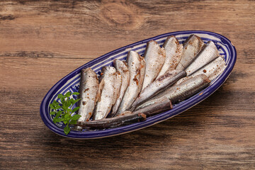 Anchovies in the bowl served basil leaves