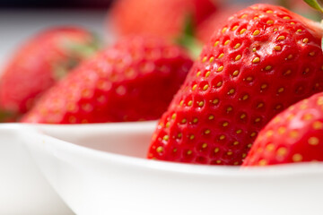 Fresh strawberry in ceramic jar on white