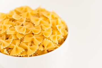 Raw dry uncooked Farfalle pasta spaghetti noodle on white bowl wooden background for basil tomato pesto sauce Homemade Italian food organic whole wheat vegan spaghetti for a healthy meal