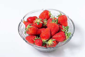 Fresh strawberry in ceramic jar on white