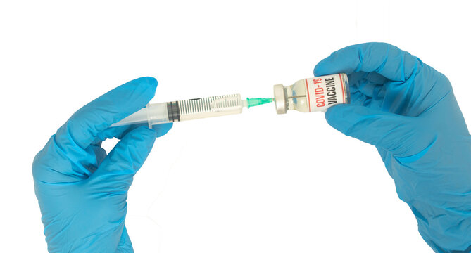 Drugs for coronavirus (covid 19) pandemic virus isolated on a white background, held by a blue doctor glove. Medicines used in virus treatment. The concept of taking the drug by syringe.