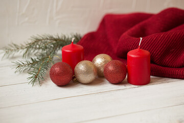 Christmas composition. Candle, Christmas tree, decorations and warm plaid on a white wooden background.