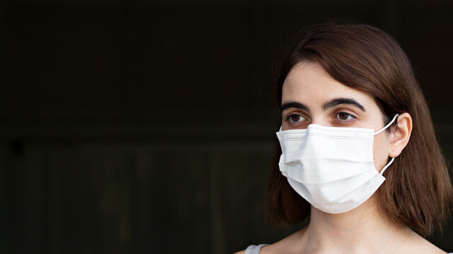 Shallow Focus Of A Brunette Female Wearing A Facemask Outdoors - COVID-19