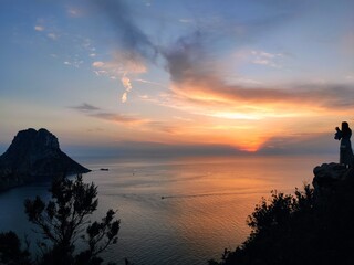 Fototapeta na wymiar Tourist takes a photo with an amazing sunset in the mountains in Ibiza,Spain
