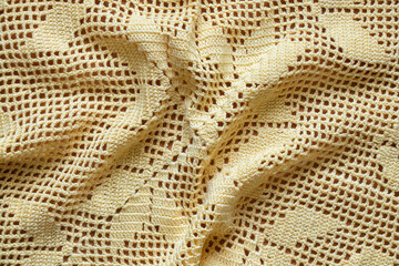 lace knitted doily light yellow as background close up