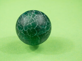 Natural stone bead close-up. Green mineral. Green background. Macro.