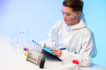 Laboratory assistant at the table in the medical laboratory. Girl records the results of tests. Testing new drugs. Research in the field of pharmacology. Sale of laboratory equipment.