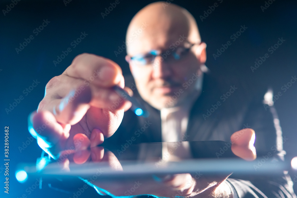Poster the man controls the tablet with a stylus. blurred technical background. touch screen technology. to