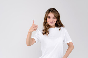 Happy beautiful woman showing thumbs up symbol by one hand. Isolated on white background